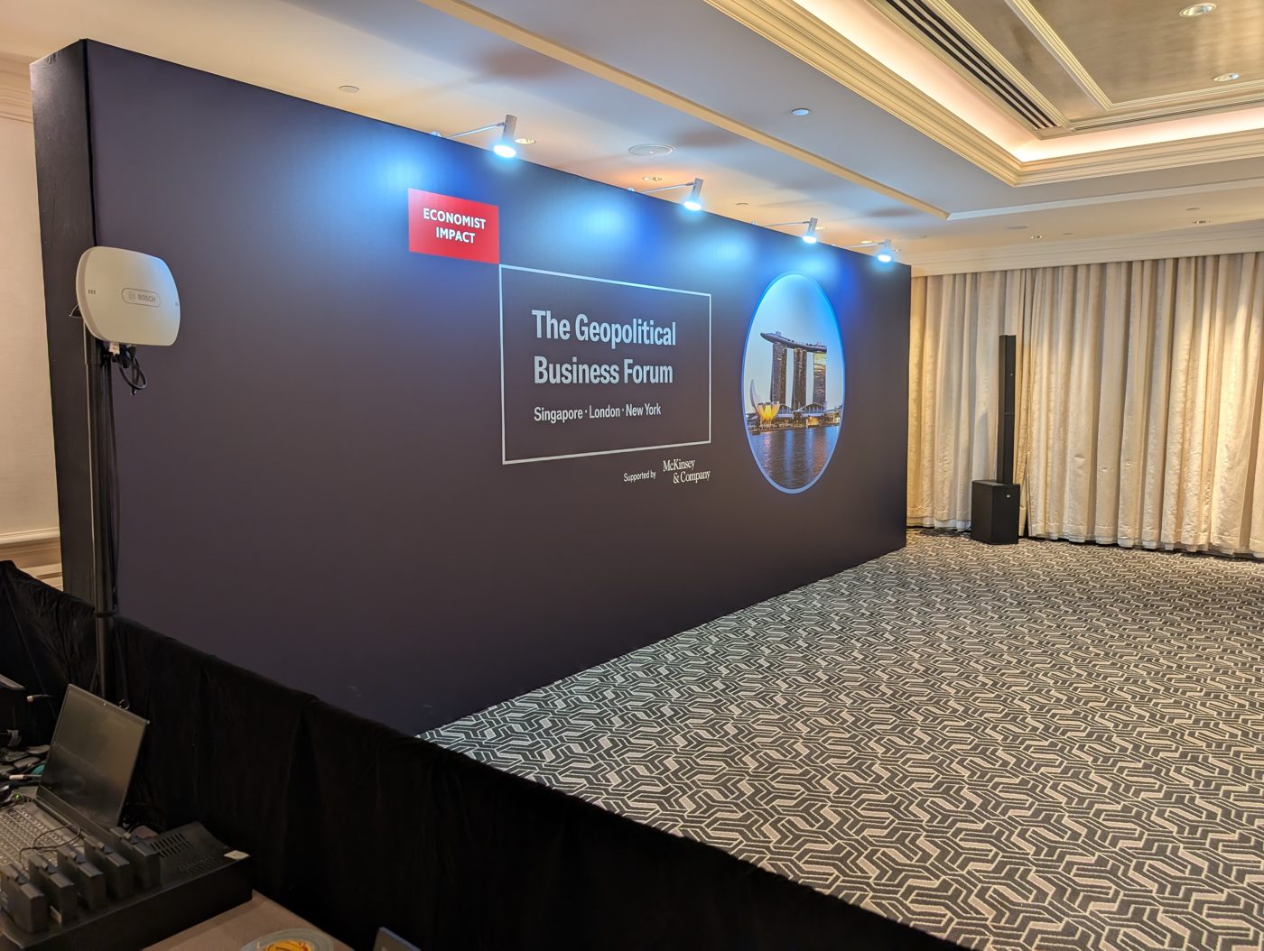 Crew preparing the branded backdrop before The Geopolitical Business Forum 2025